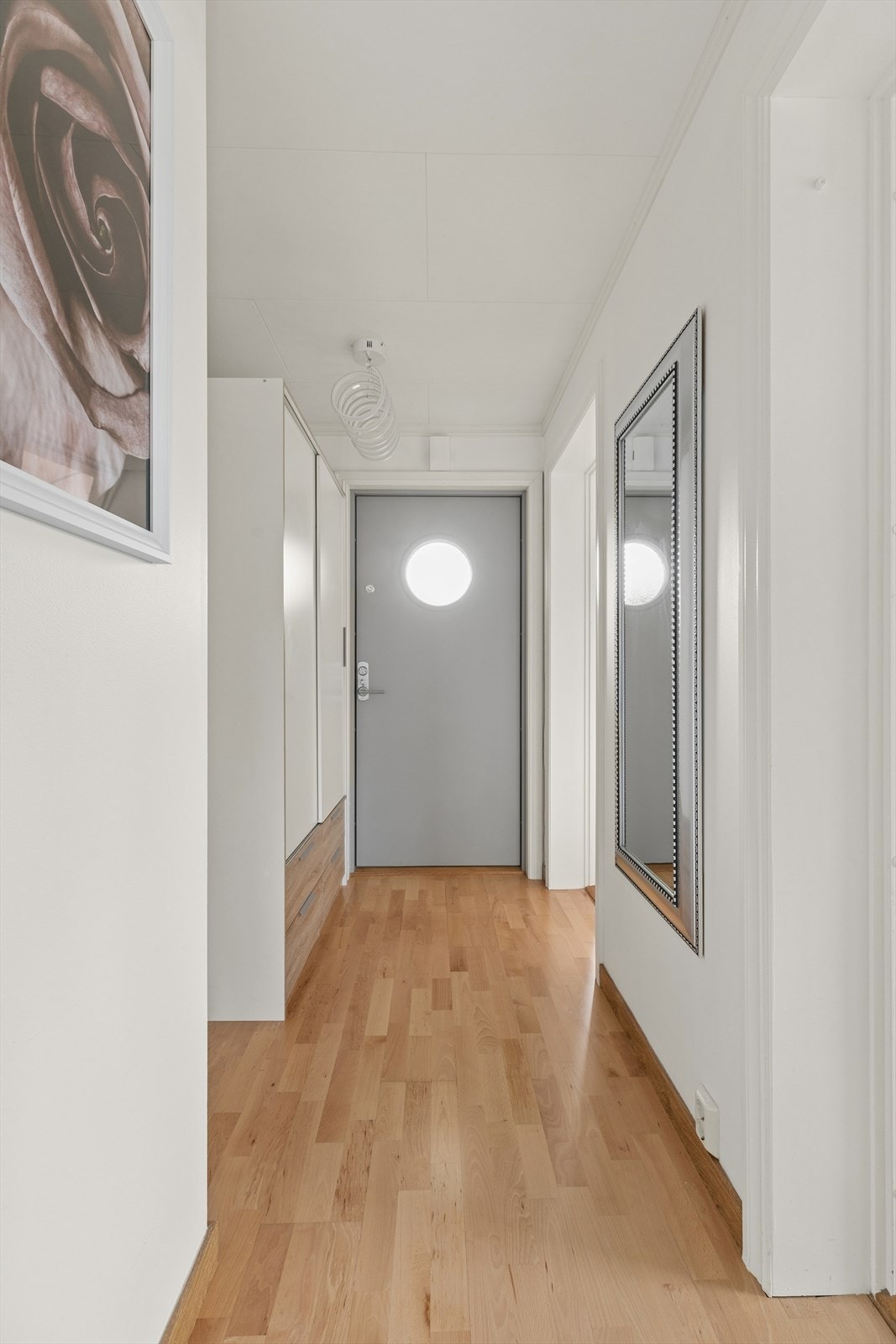 Entréen har parkett på gulv og malte flater, og leder videre inn i boligen. Galleribilde