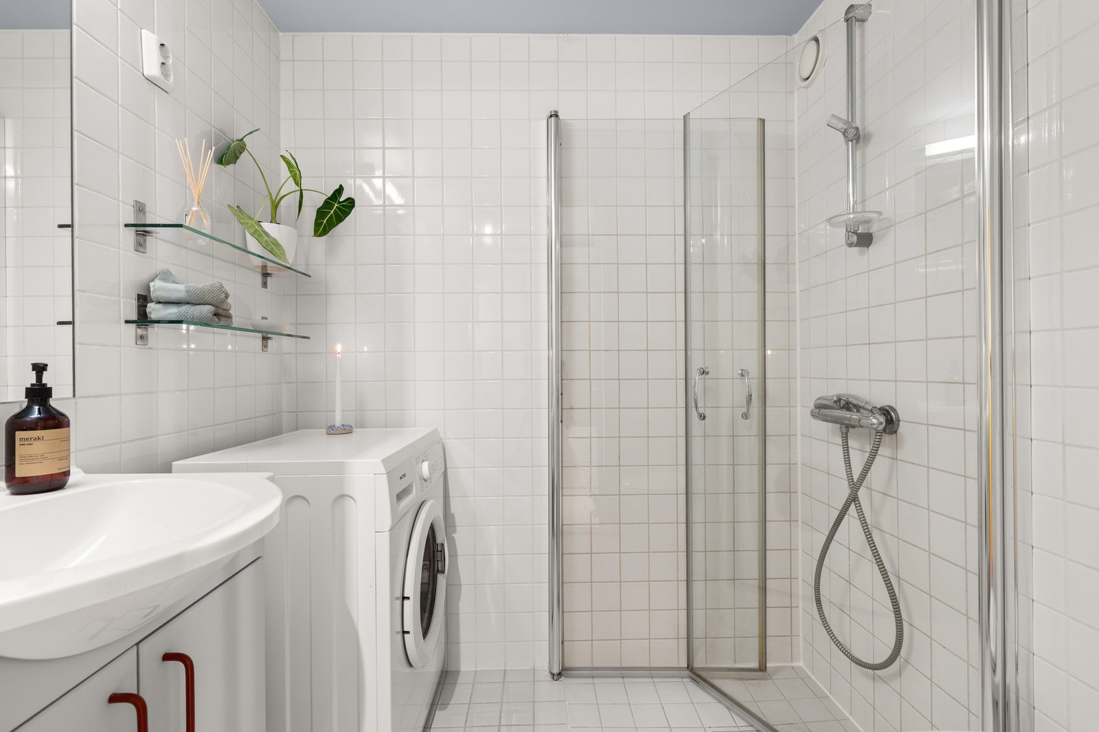 Pent, flislagt baderom med varmekabler på gulvet og opplegg for vaskemaskin. Galleribilde