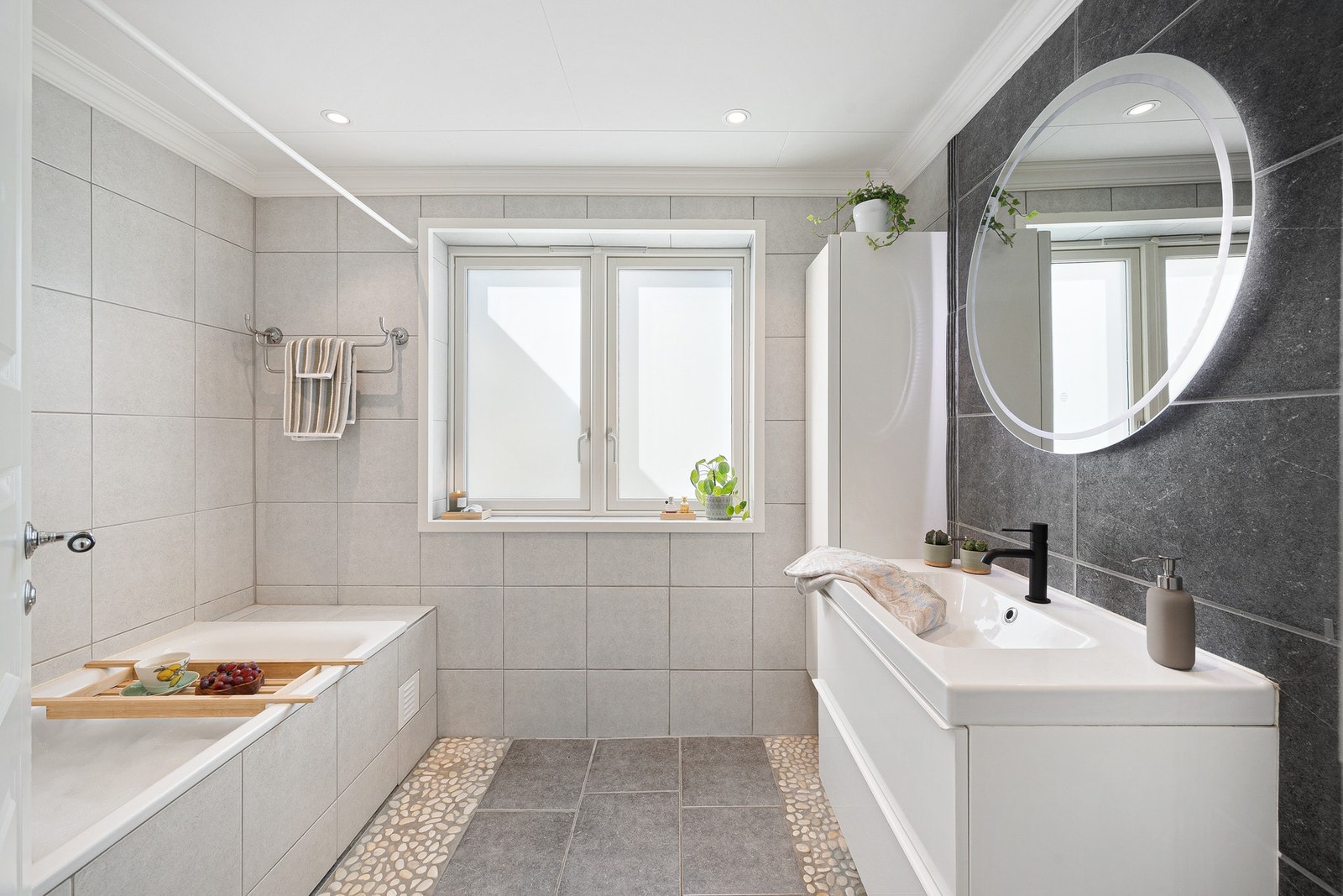 Et flott og tidløst bad, med flislagte vegger og gulv. Badet er, som øvrige rom i leiligheten, både romslig og innbydende. Badet ble sist pusset opp i 2010. Galleribilde