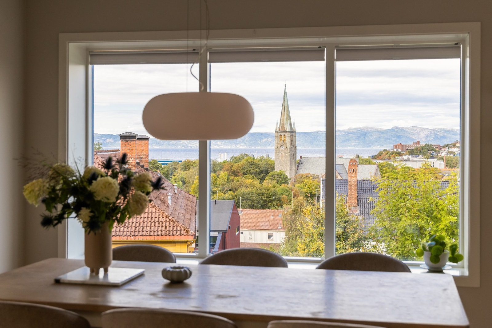 Utsikt mot Lademoen kirke, fjorden og Fosenalpene i bakgrunn. Galleribilde