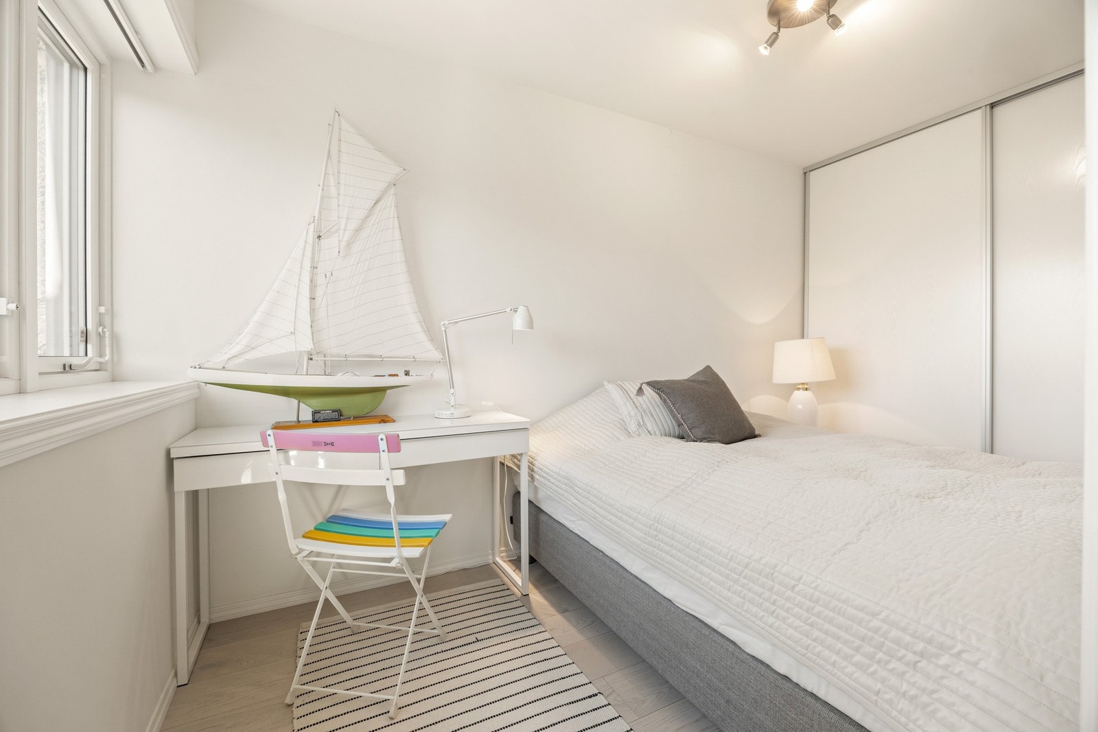 Fra hybelen - Lyst soverom med innebygd garderobe og skrivebord ved vinduet. Galleribilde