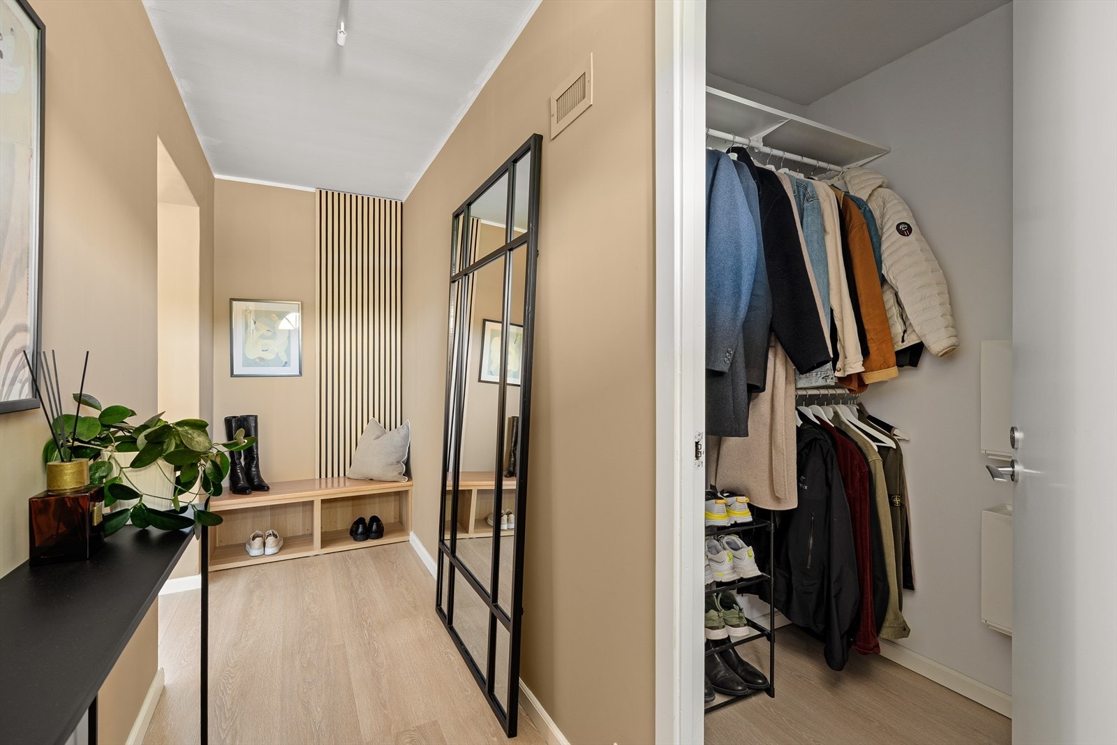 En innbydende entré med god plass til yttertøy og sko. Rett innenfor døren ligger en praktisk bod for ekstra oppbevaring. Galleribilde