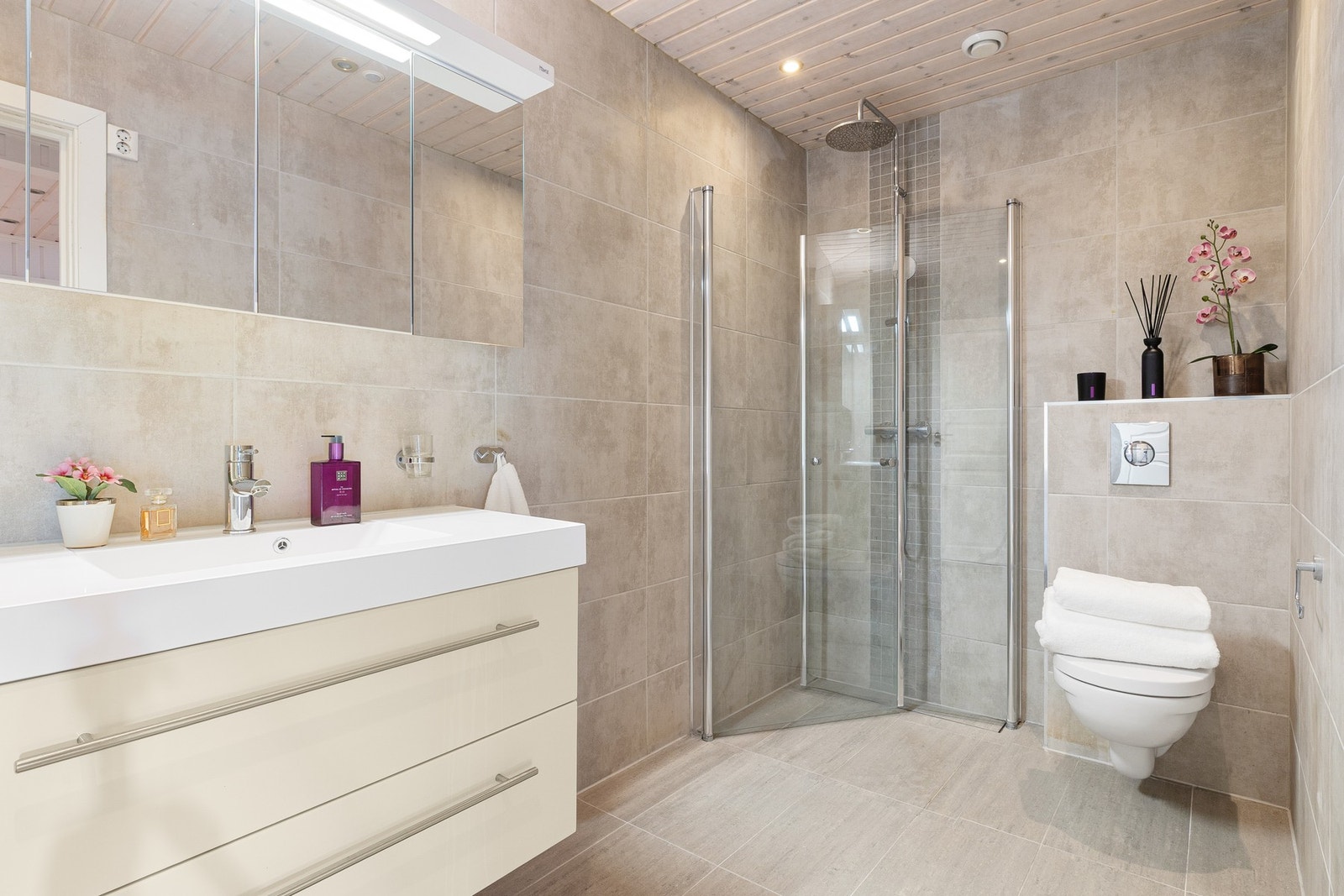 Badet ble renovert i 2017 og er pent utført med store vegg- og gulvfliser i beige, varmekabler og downlights. Galleribilde
