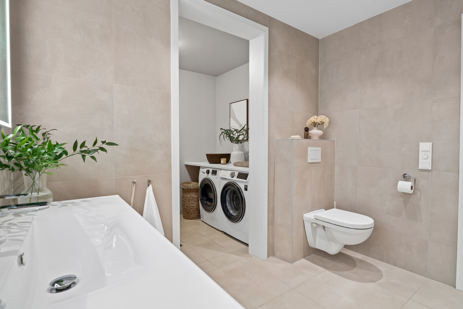 Badet har direkte tilgang til et separat vaskerom med opplegg for både vaskemaskin og tørketrommel. Vaskerommet har flislagt gulv, varmekabler og sluk. Galleribilde
