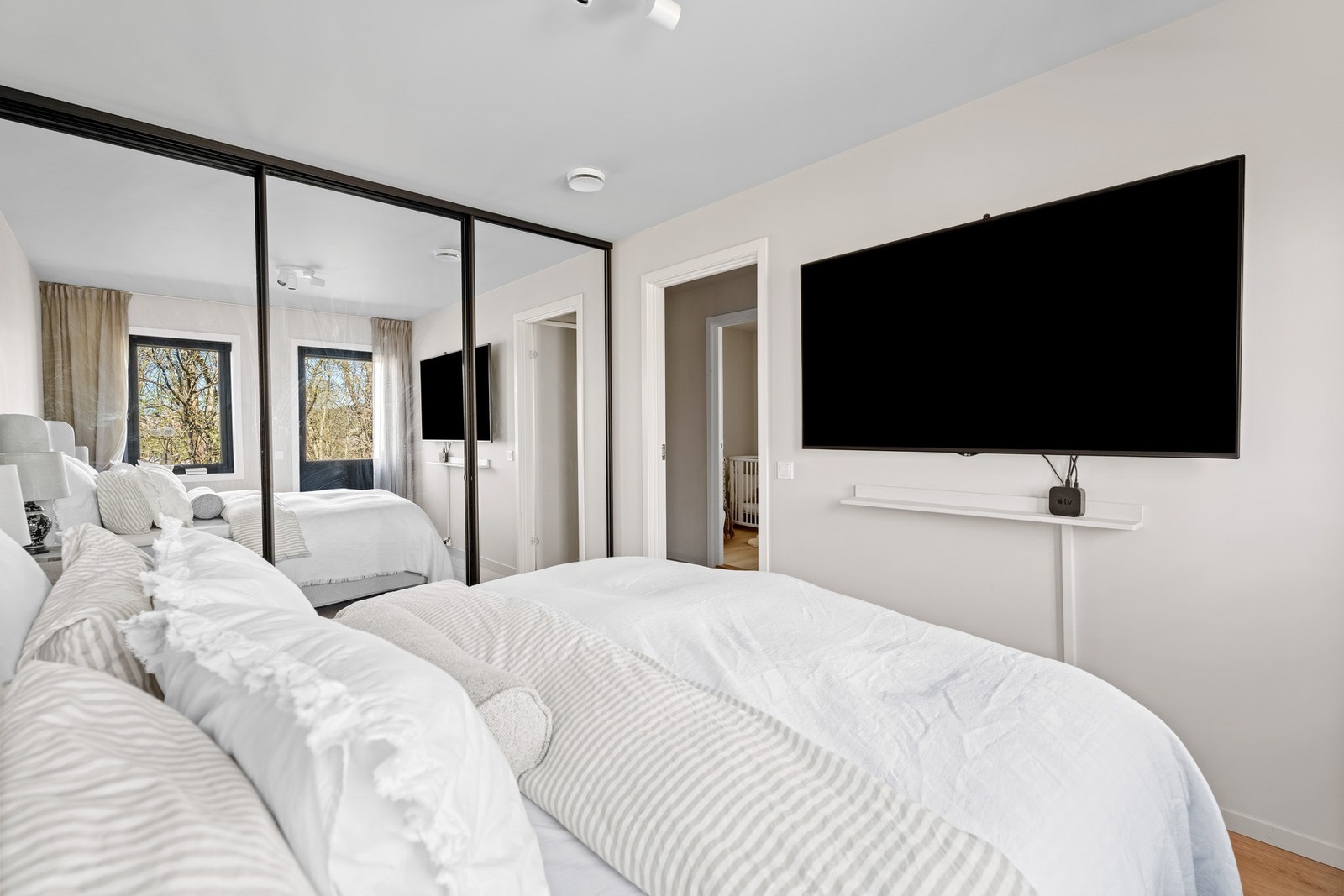 Det er gode oppbevaringsløsninger i form av en romslig skyvedørsgarderobe med speilfronter. Rommet har utgang til hagen på baksiden av boligen. Galleribilde