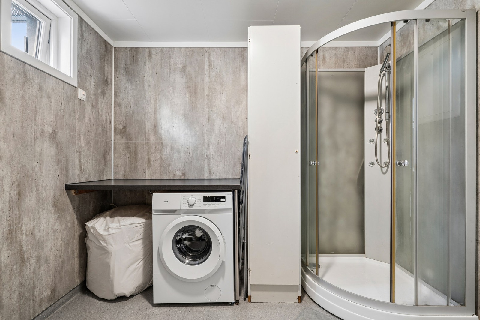 Badet er utstyrt med dusj, servant og opplegg for vaskemaskin. Galleribilde