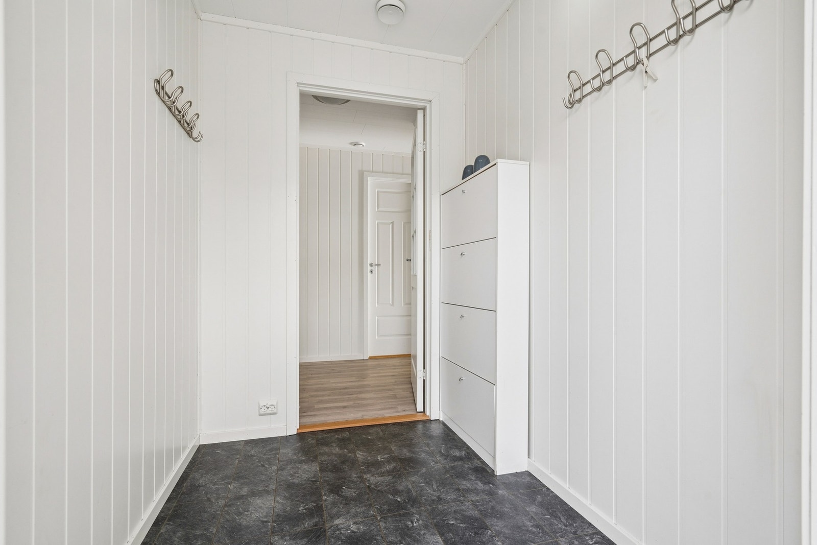 Lys entré med plass til oppbevaring og naturlig adkomst videre inn i boligen. Galleribilde