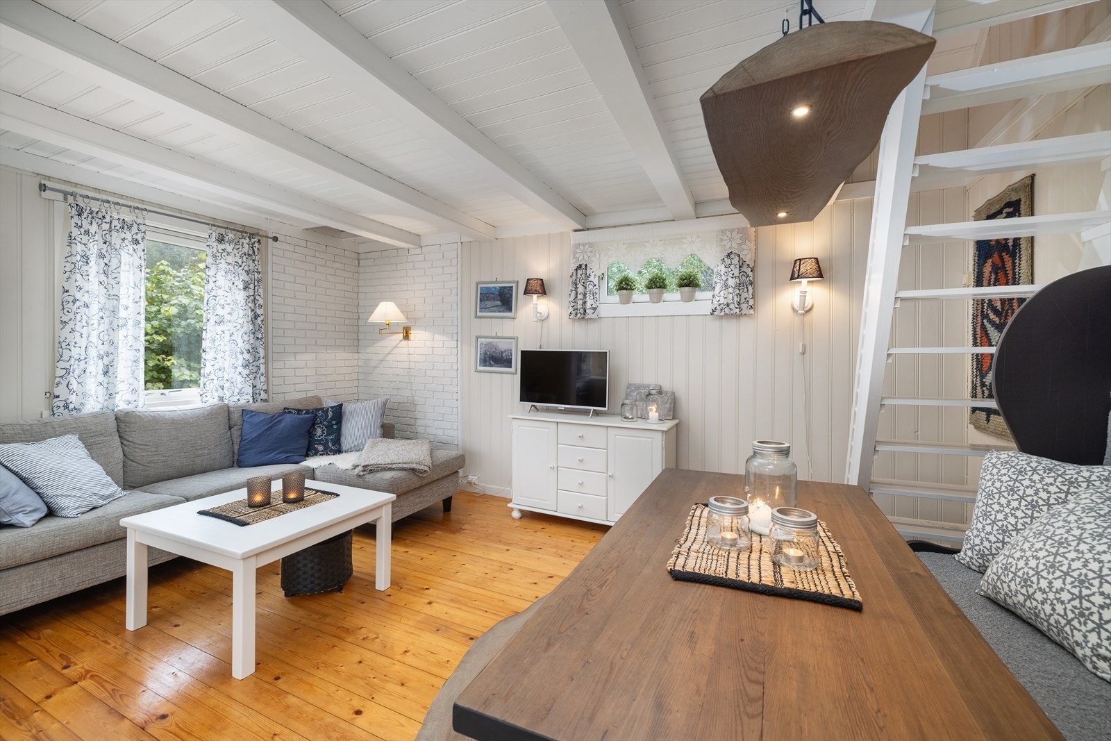 Stue og kjøkken har åpen løsning, og det er trapp opp til hems med ekstra soveplass. Galleribilde