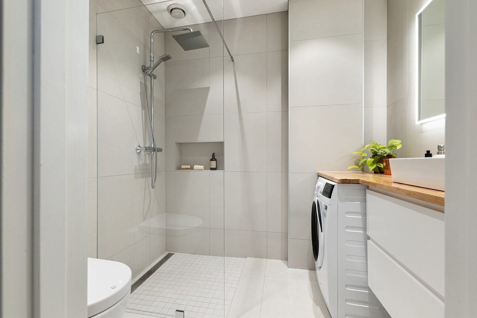Badet har vegghengt toalett, opplegg for vaskemaskin samt benkeplate i tre som ble slipt i 2025, med hvit servant ny fra 2025 og blandebatteri. Veggmontert speil med integrert belysning. Rommet har naturlig ventilasjon. Galleribilde