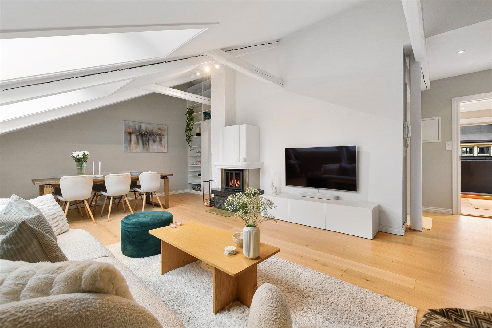 Store vindusflater slipper inn rikelig med naturlig lys, mens synlige takbjelker tilfører boligen et klassisk og sjarmerende preg. Galleribilde