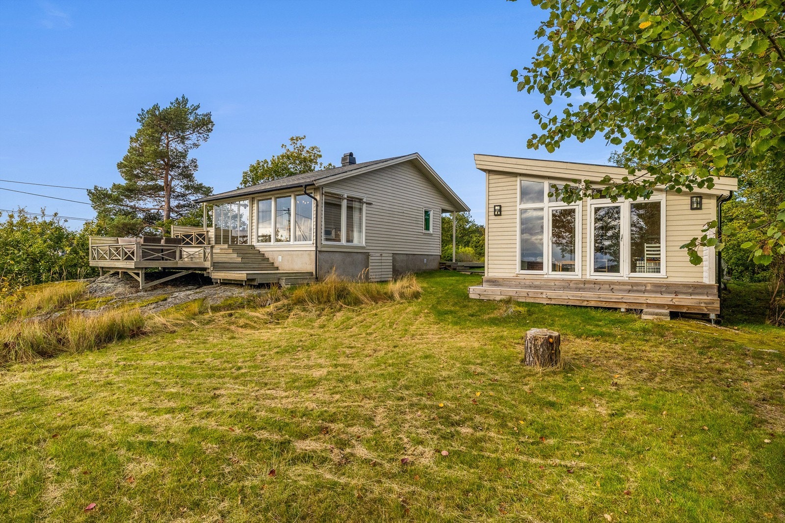 Tomten er naturskjønn med gressplen og svaberg. Galleribilde