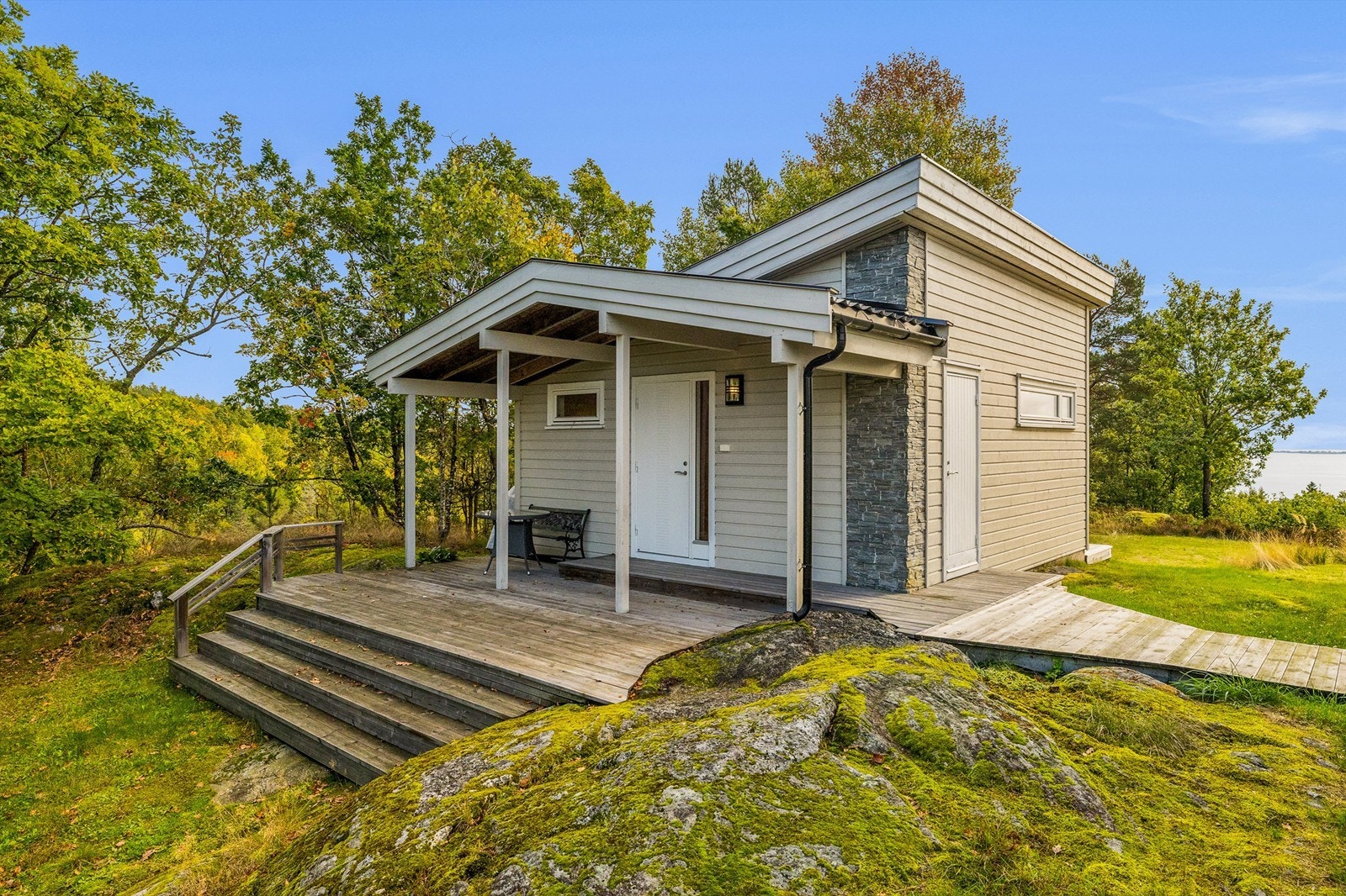 Annekset har en moderne arkitektur med overbygd inngangsparti og terrasse. Galleribilde