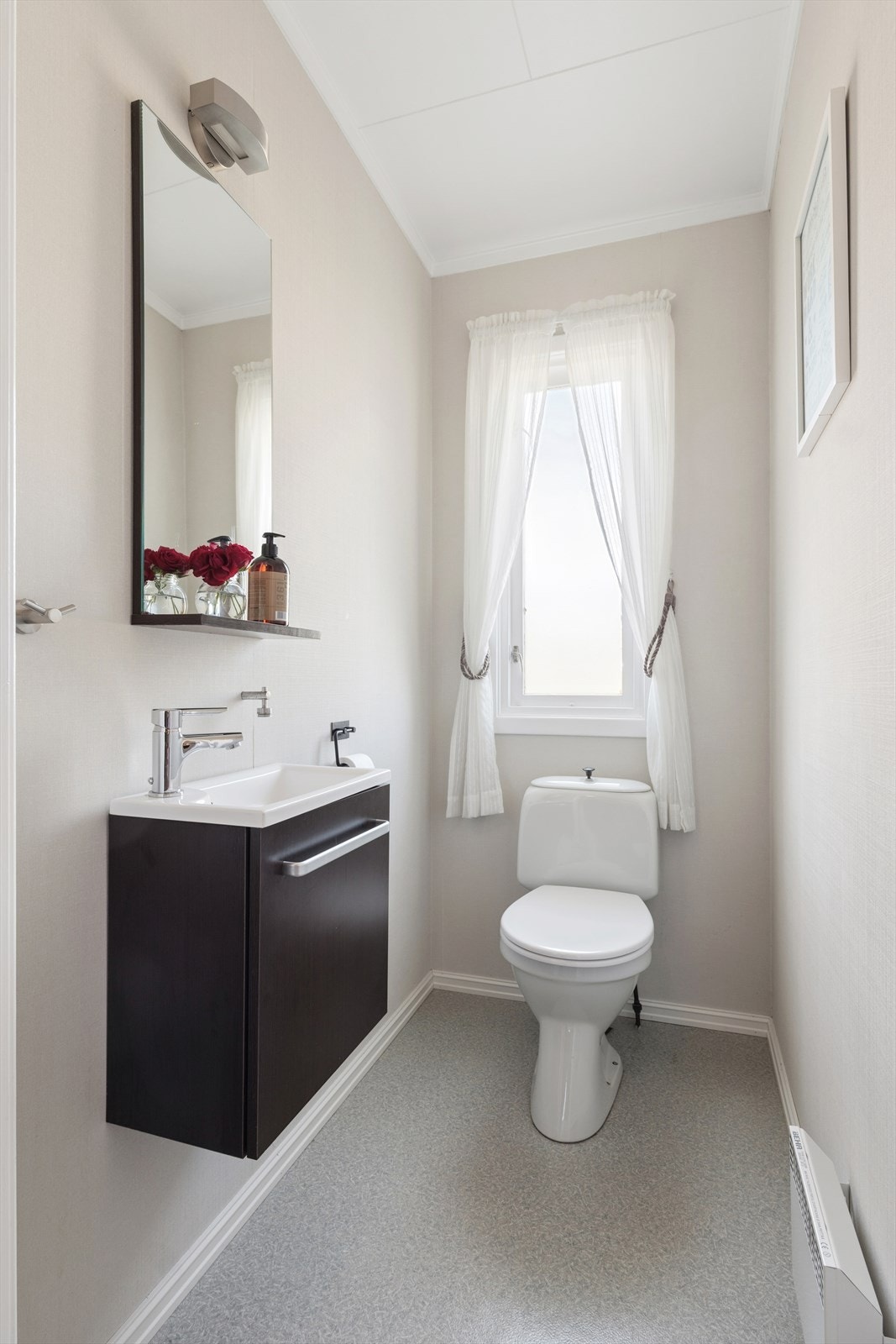 Like ved badet er det toalettrom med belegg på gulv og malte vegger Galleribilde