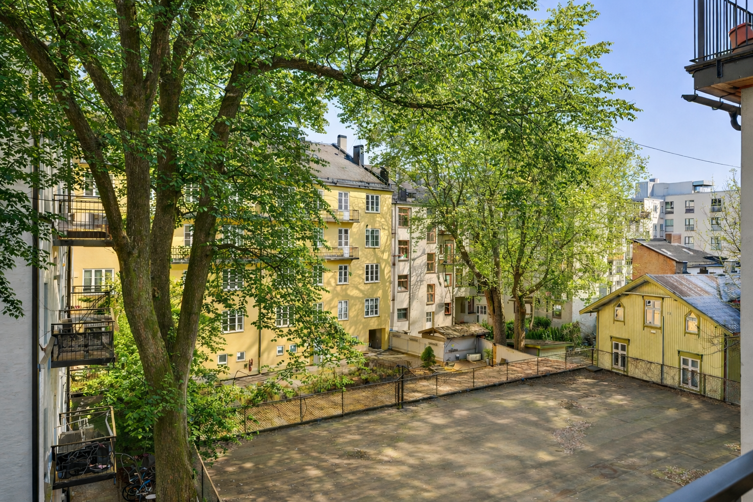 Utsikt fra balkong mot bakgård ved sommerstid - AI redigert. Galleribilde