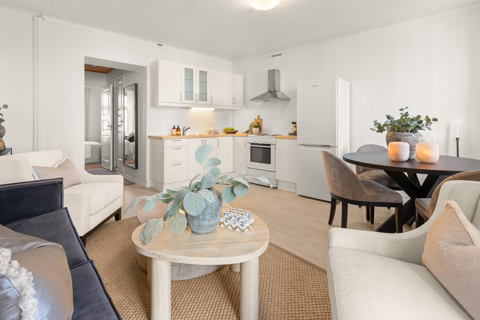 Velkommen inn i en innbydende leilighet med en harmonisk kombinasjon av stue og kjøkken, hvor gode møbleringssoner og behagelige fargetoner skaper en lun og hjemmekoselig atmosfære. Galleribilde