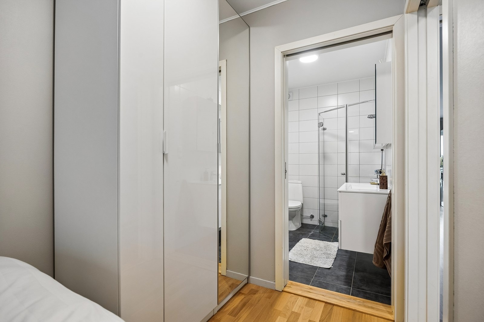 Soverommet har direkte tilgang til badet og er innredet med en funksjonell garderobeløsning med speil. Galleribilde