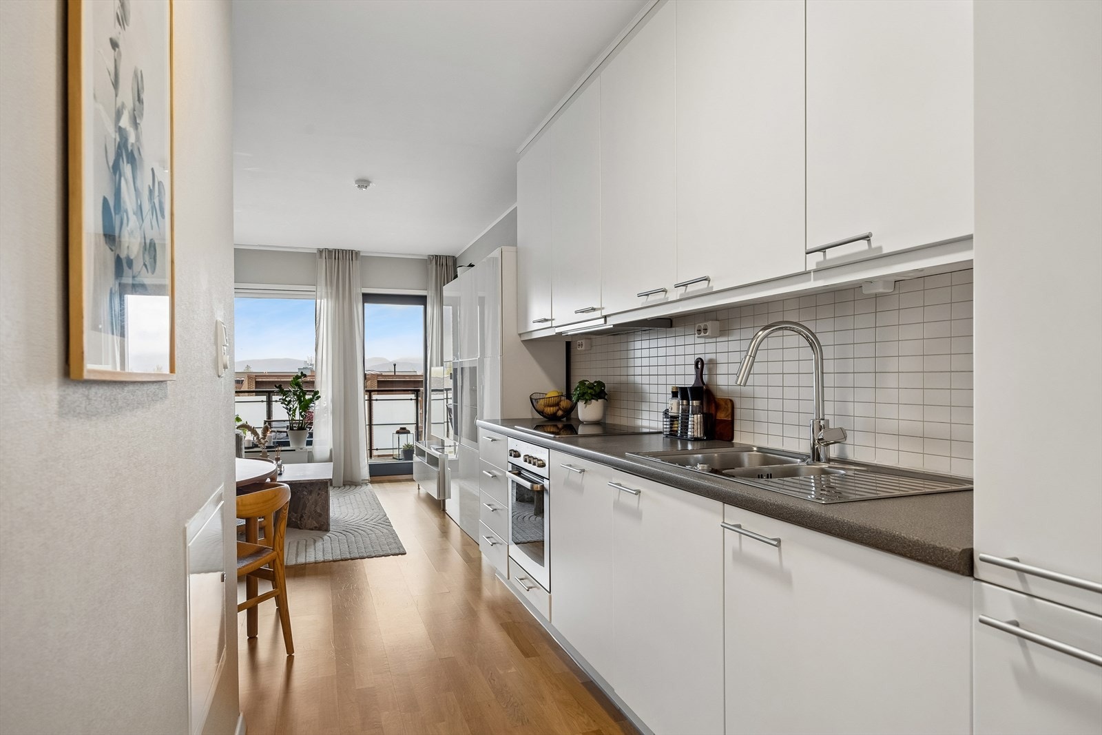 Kjøkkenet er stilrent med hvite fronter og laminat benkeplate. Galleribilde