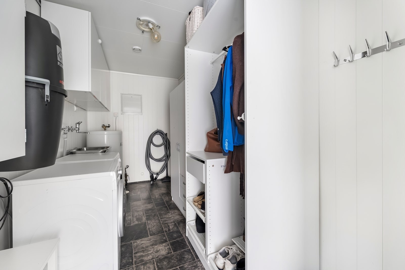 Praktisk vaskerom med opplegg for vaskemaskin og tørketrommel. God lagringsplass. Galleribilde