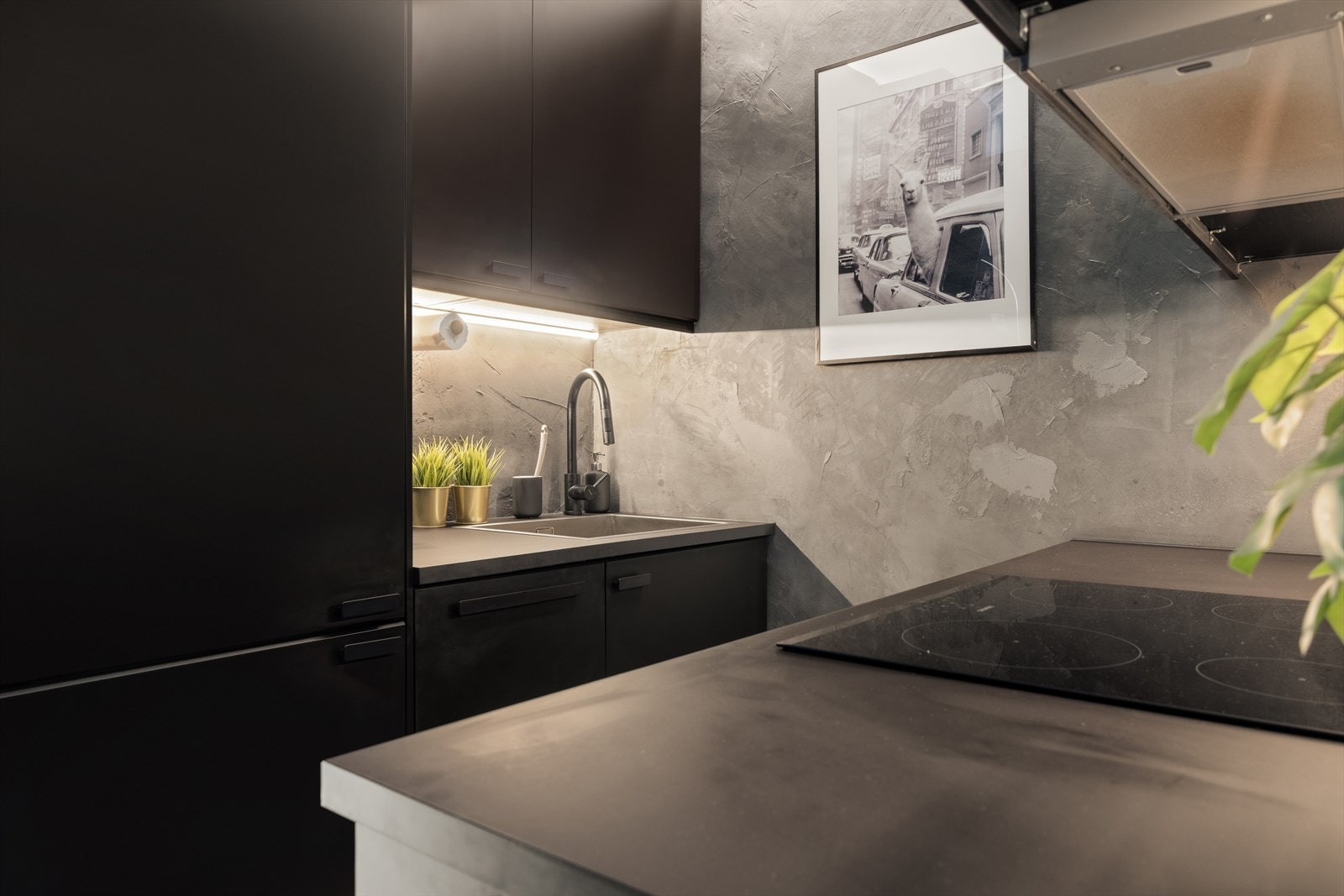 Kjøkkenet fra Ikea har lekker mørk innredning med glatte fronter og benkeplate av laminat. Galleribilde