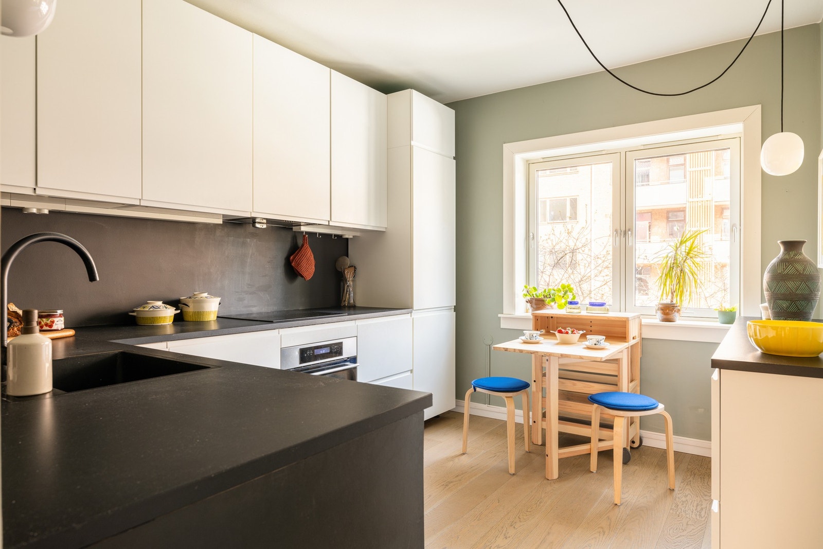 Kjøkkenet har god standard med enstavs parkett på gulv, glatte overflater malt i en fin farge og et stort vindu som slipper inn flott lys. Galleribilde