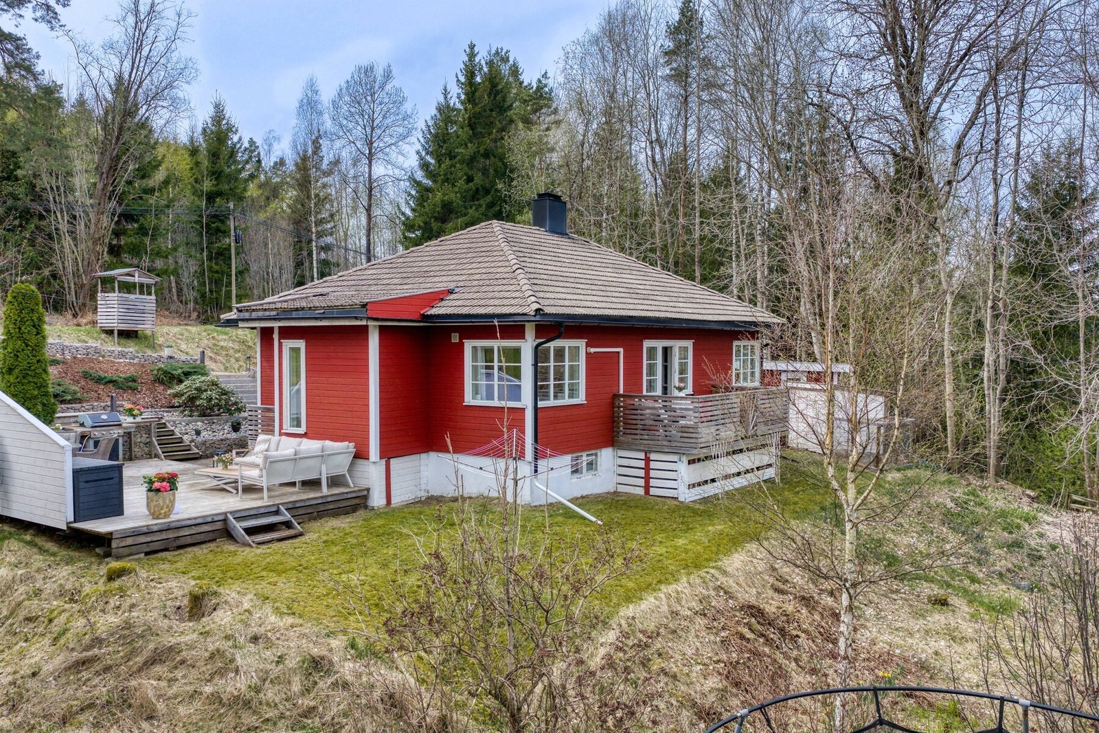 Tomten er pent opparbeidet med solrike uteplasser, gressplen, trær og beplantning. Galleribilde