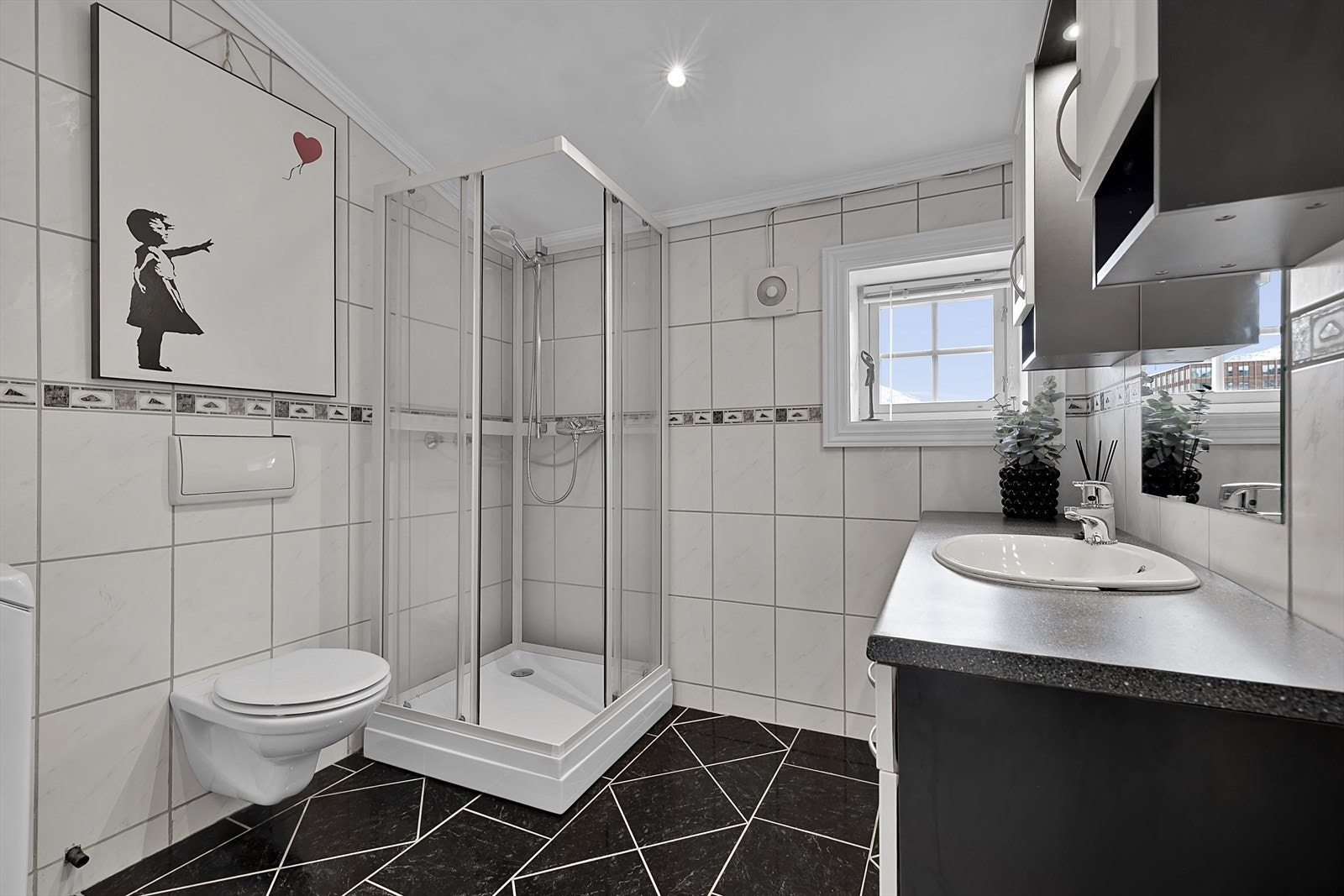 Badet er pent innredet med moderne vegghengt toalett, samt praktisk opplegg for vaskemaskin. Galleribilde