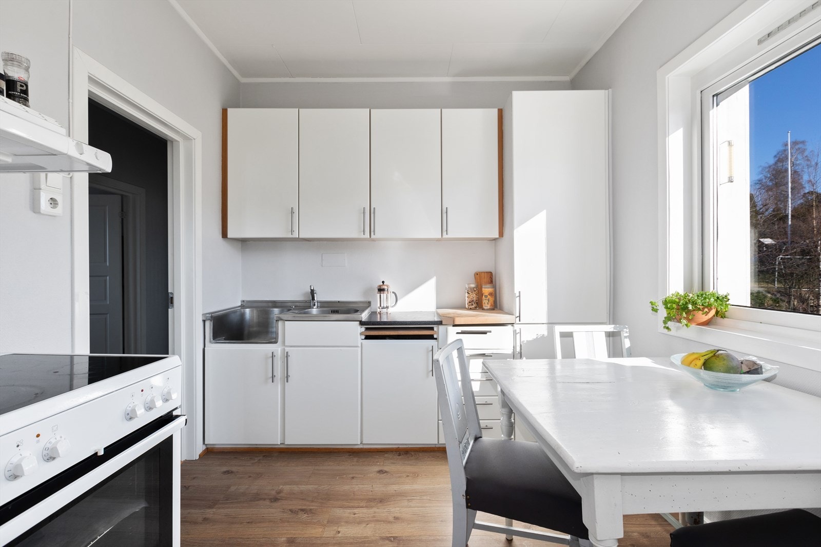 Kjøkkeninnredningen er av eldre dato, med nyere glatte fronter og laminert benkeplate med benkebeslag og nedfelt vask i rustfritt stål. Galleribilde