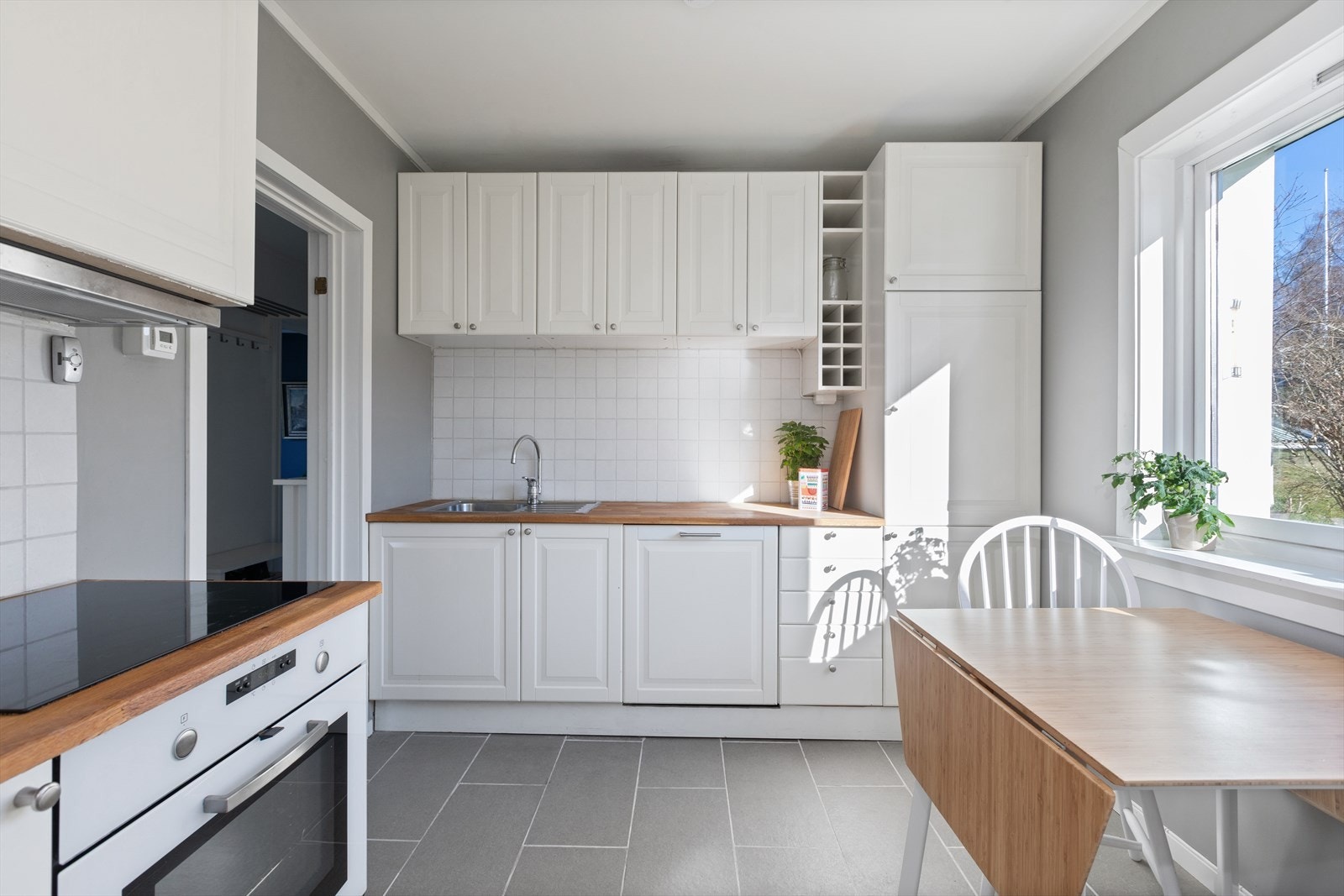 Kjøkkeninnredningen er fra 2016 og er pent utført med hvite, profilerte fronter og heltre benkeplate med nedfelt vask i rustfritt stål. Galleribilde