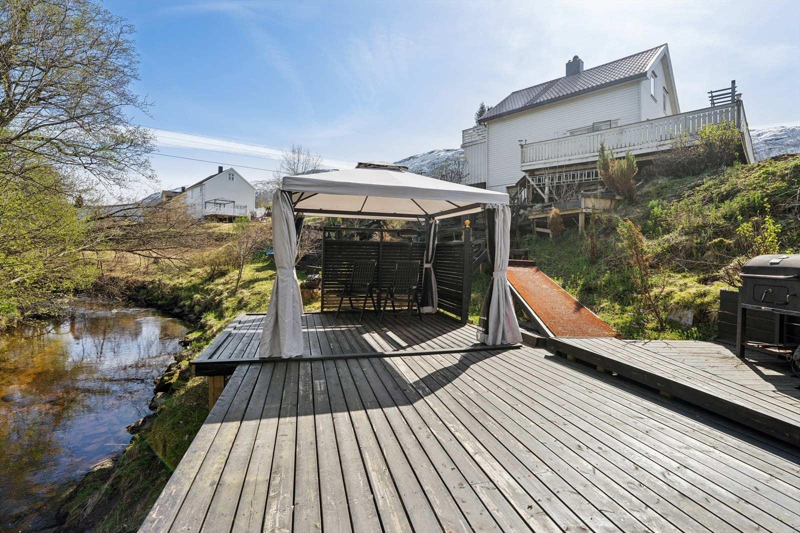 Eiendommen på 1,3 er romslig og strekker seg ned mot elven, med flere terrasser og en idyllisk platting i terrenget. Galleribilde
