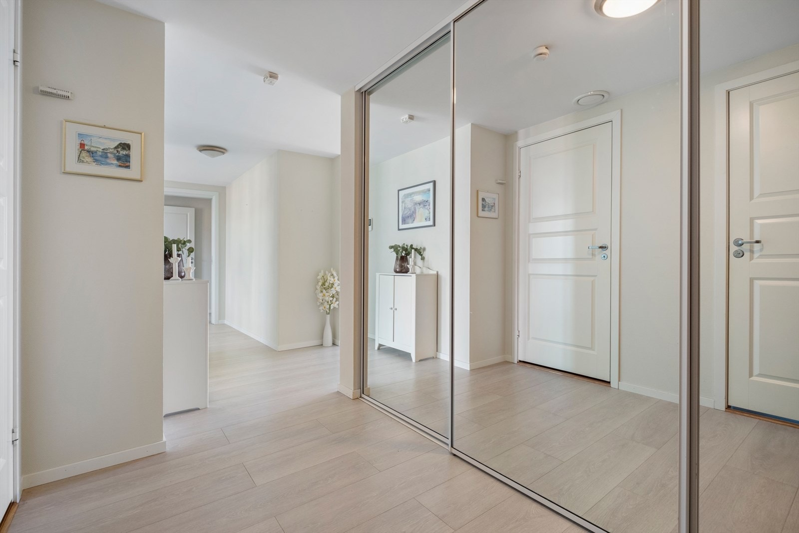 Hyggelig entrè/gang som har rikelig med oppbevaring i form av skyvedørsgarderobe Galleribilde