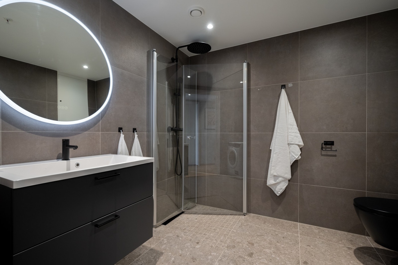 Lekkert, flislagt baderom med inngang fra entré med varme i gulv og downlights i himling. Badet er oppgradert med nøye utvalgte tilvalg som tilfører elegante detaljer og en eksklusiv finish. Galleribilde