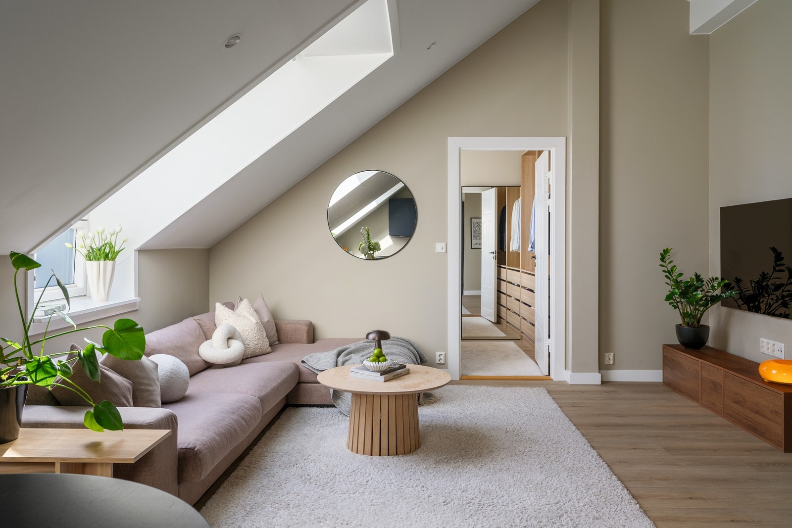 Her møtes moderne komfort og klassisk loftspreg i en gjennomført helhet, med skråtak og takvinduer som naturlige blikkfang. Galleribilde