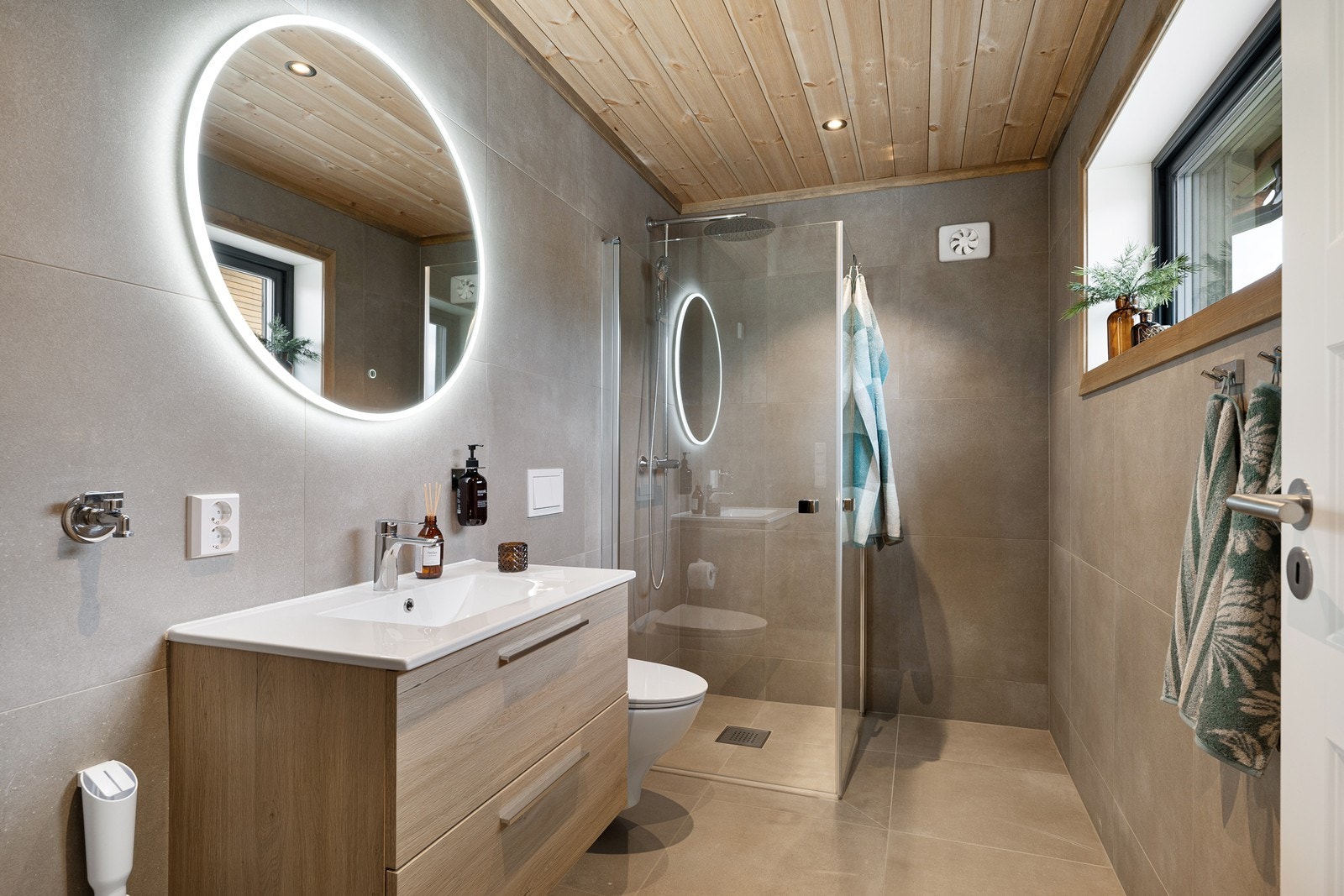 Det delikate og moderne badet ligger i første etasje og har vegghengt toalett, samt dusjhjørne med innfellbare glassdører og både regnfall- og hånddusj. Galleribilde