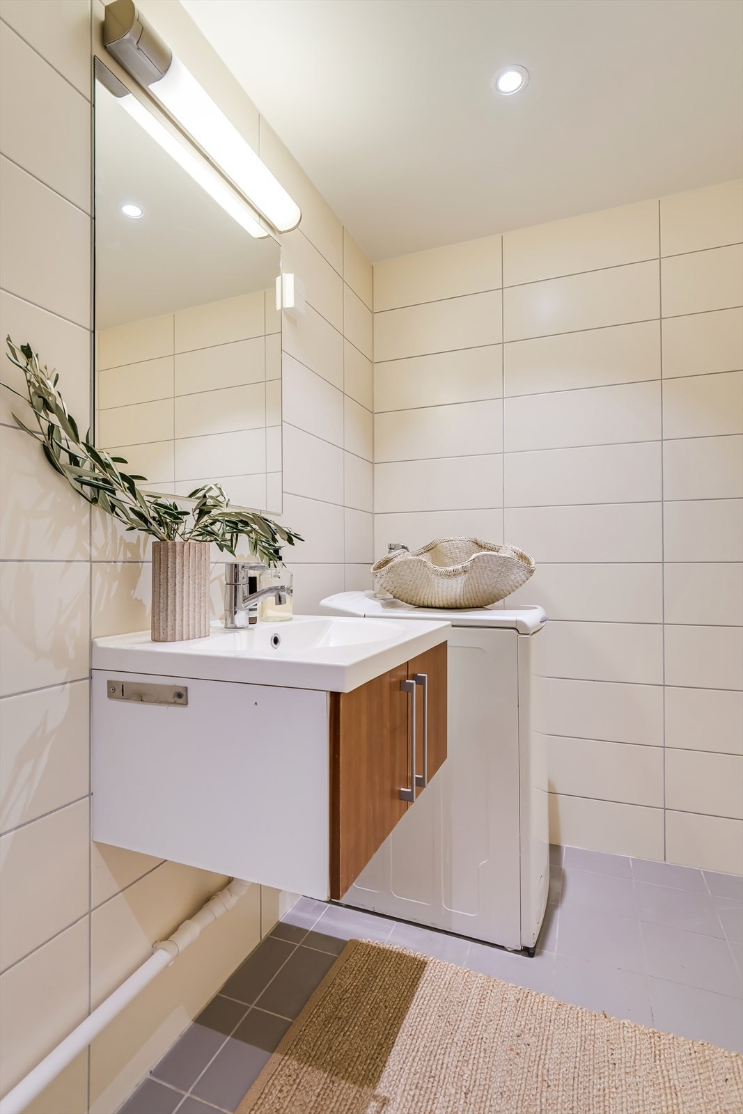 Innredningen består av nedfelt servant med underskap, speil, vegghengt toalett og dusjkabinett. Galleribilde