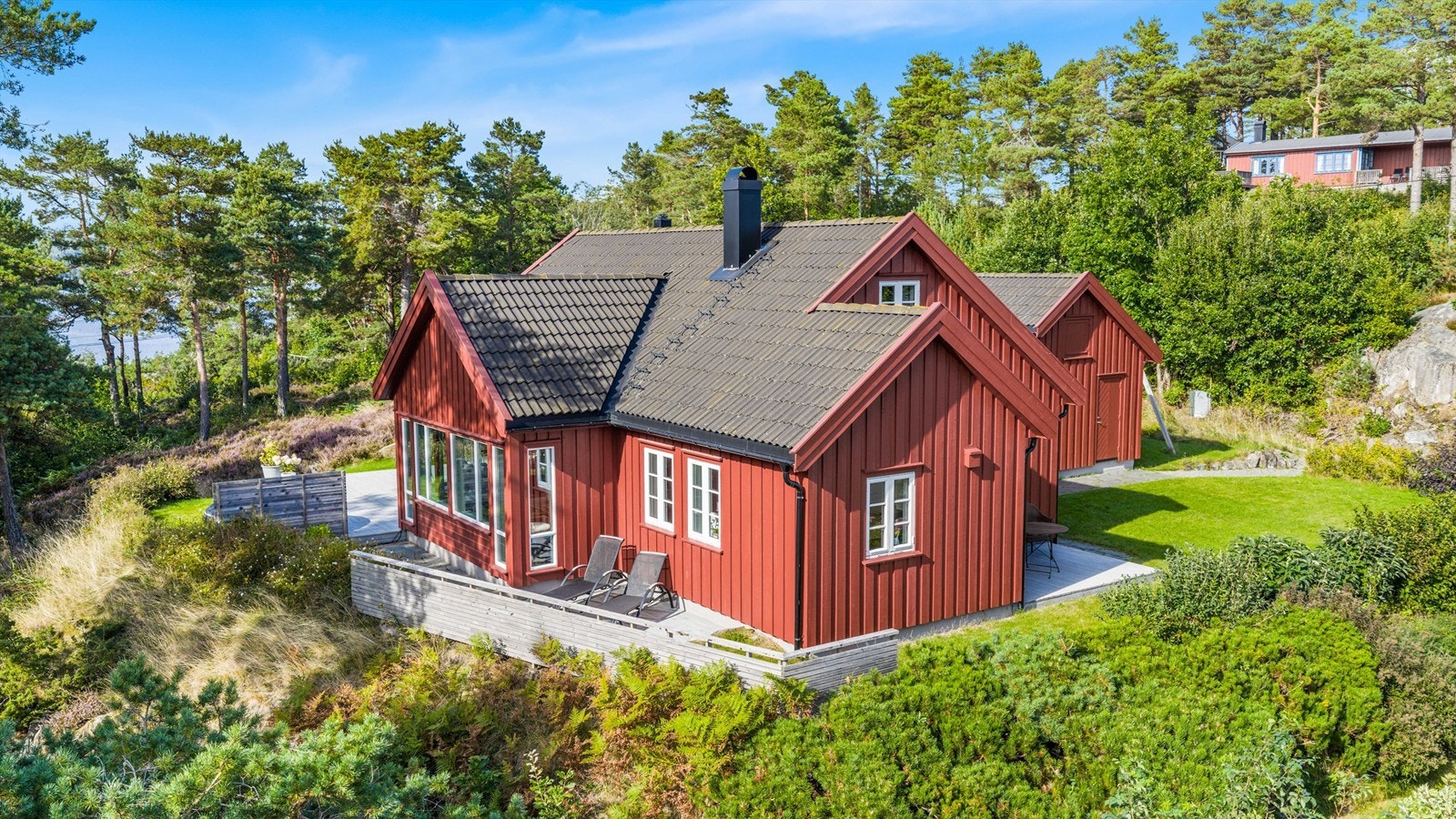Usjenert og sjønær eiendom på Tromøy med fritidsbolig og anneks, omkranset av stor terrasse og naturskjønne omgivelser. Galleribilde