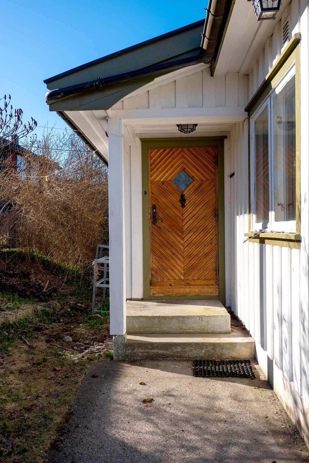 Fra gårdsplass og sti ankommer du boligens inngangsparti på baksiden av huset. Galleribilde
