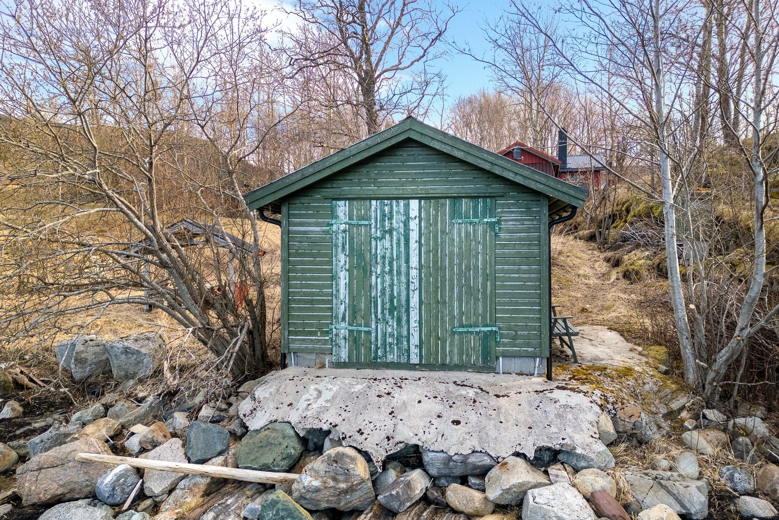 Naustet er pent og naturlig integrert i terrenget Galleribilde