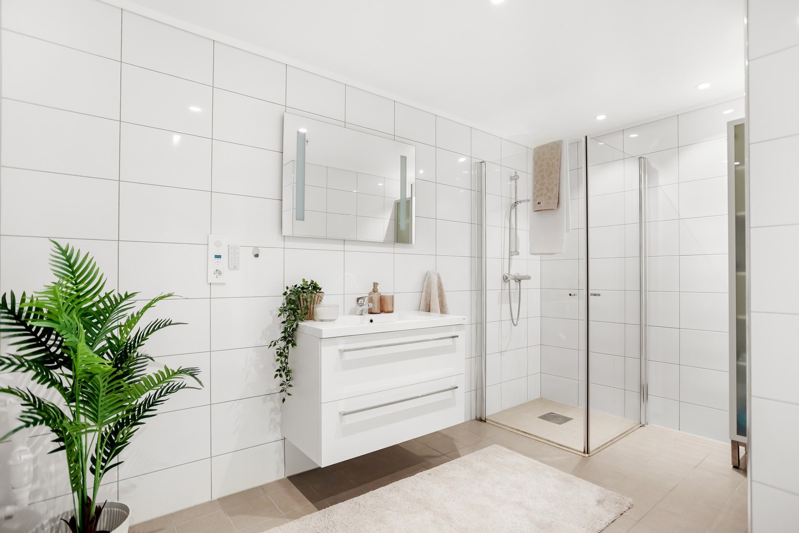 Badet holder en gjennomgående lys og stilren standard, med fliser på både gulv og vegger. Galleribilde