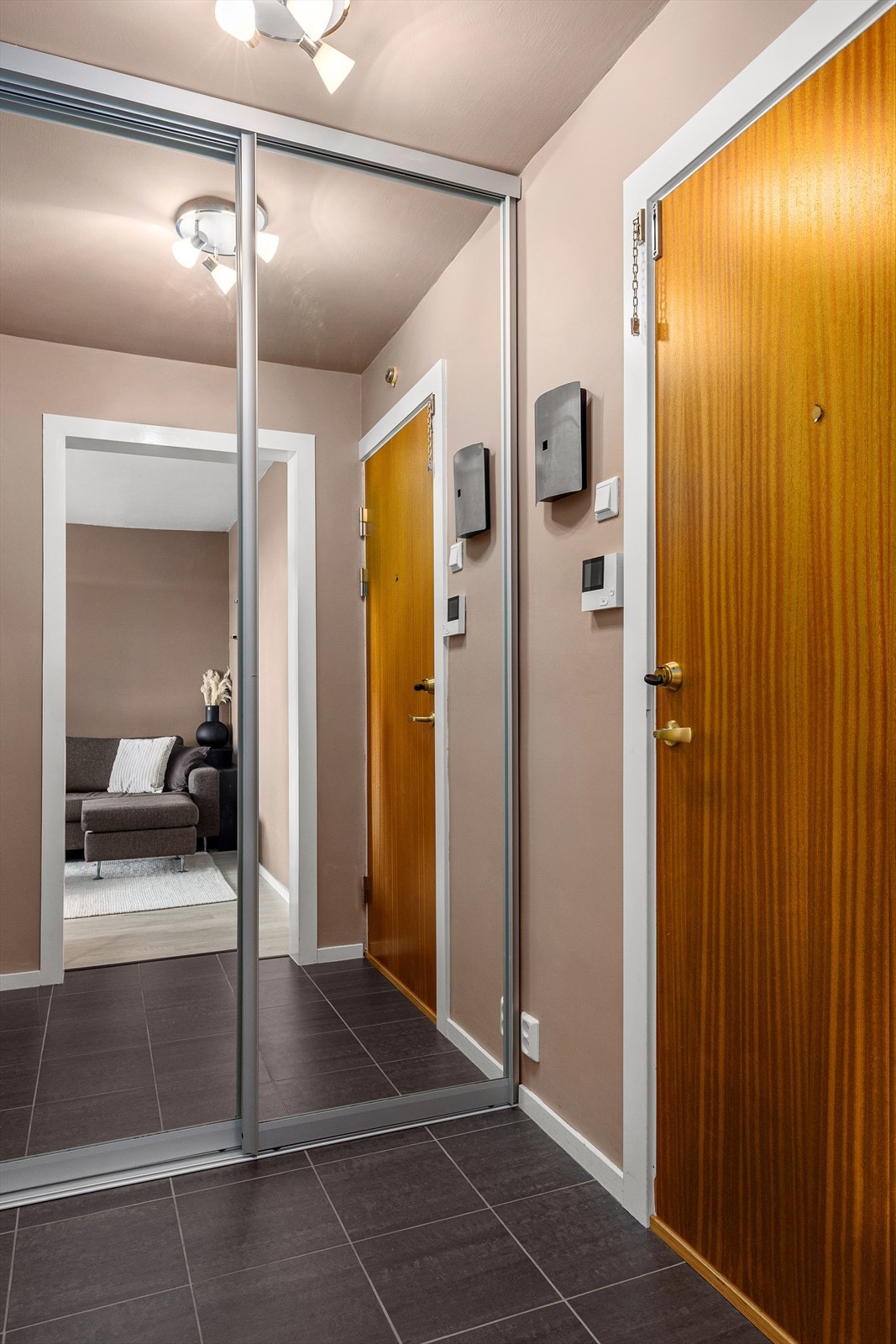 Romslig og praktisk entré med god oppbevaringsplass i skyvedørsgarderobe med speilfronter. Galleribilde