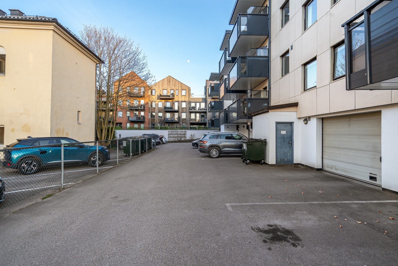 På baksiden av bygget er det felles parkeringsplass, samt garasjeport inn til parkeringskjelleren Galleribilde