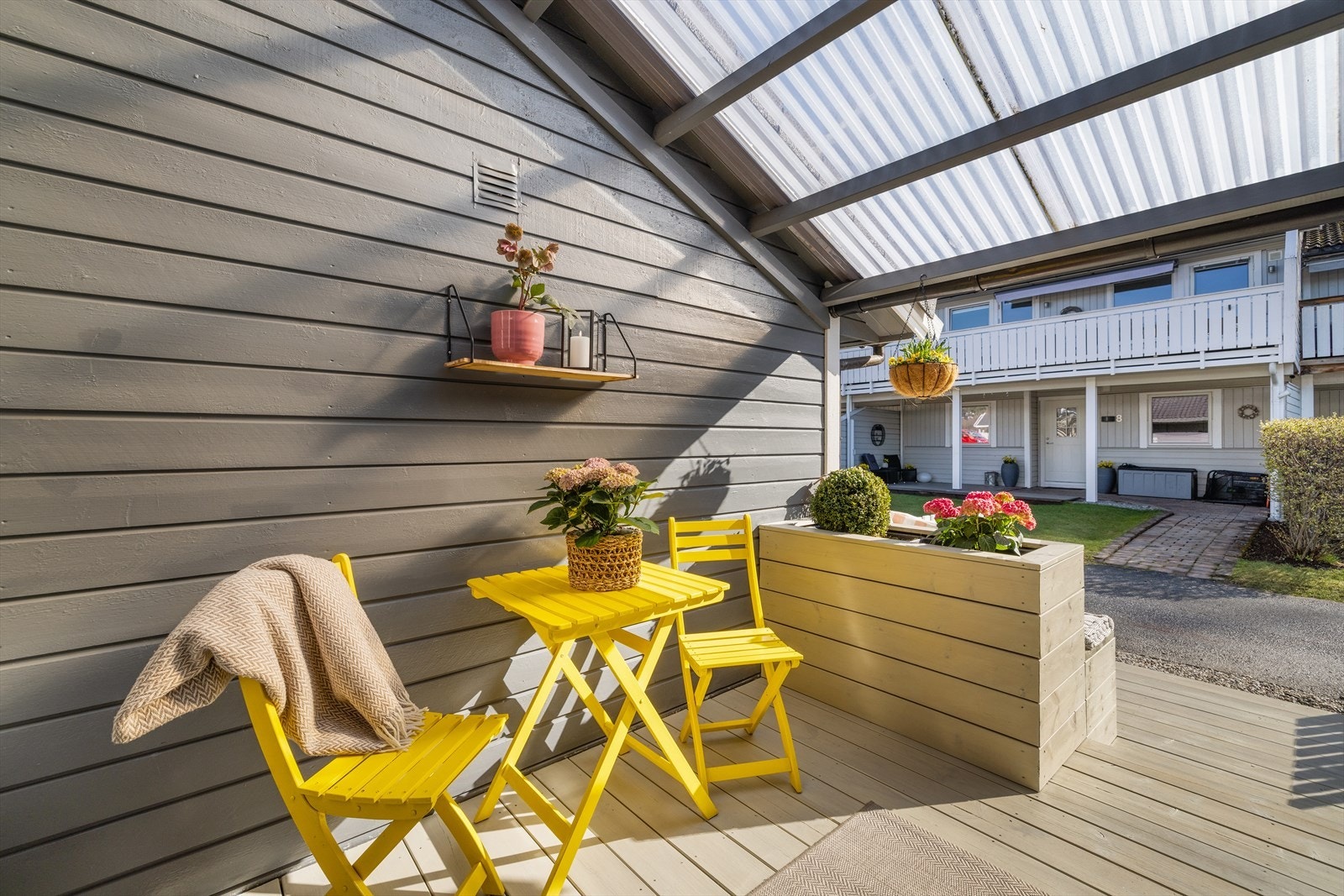 Det overbygde inngangspartiet gir ly for vær og vind, og har plass til en liten sittegruppe. Galleribilde