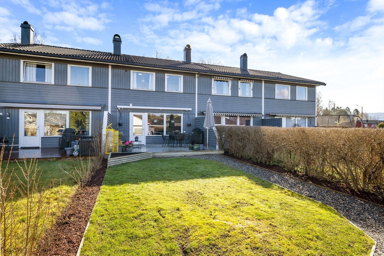 Hagen er pent opparbeidet med plen og hekk, og gir en fin ramme rundt uteplassen. Galleribilde