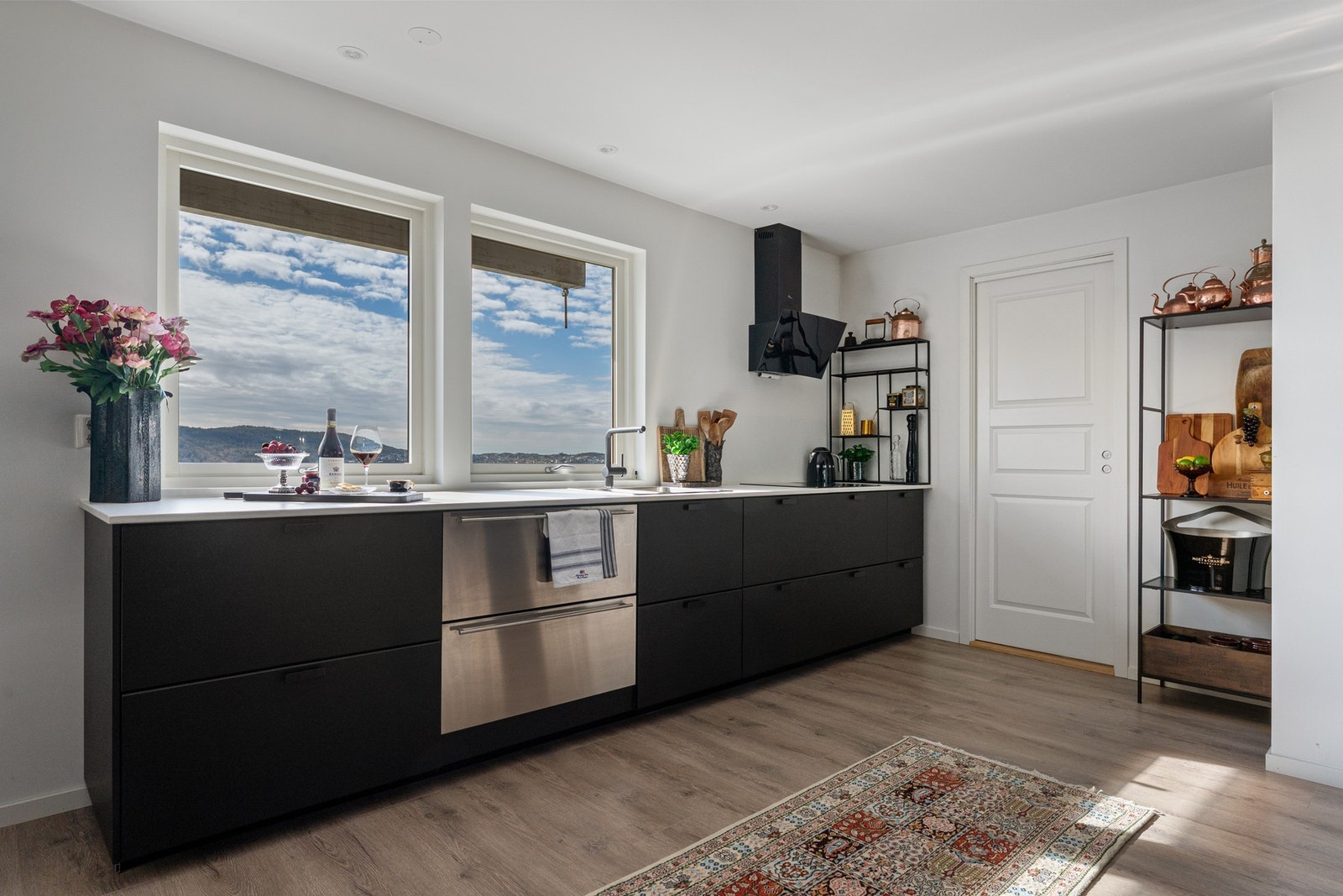 Stilrent kjøkken fra 2020 med slette fronter og benkeplate i stein fra Nerostein. Praktisk utstyrt med oppvaskkum i stål og ventilator. Galleribilde