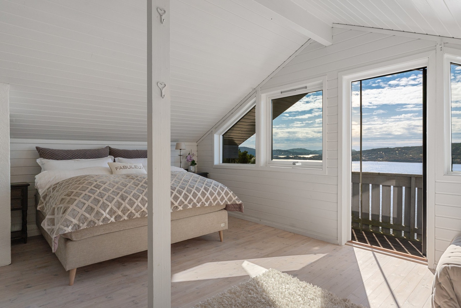 Soverom med store vindusflater som slipper inn rikelig med naturlig lys og skaper en lys og behagelig atmosfære. Galleribilde