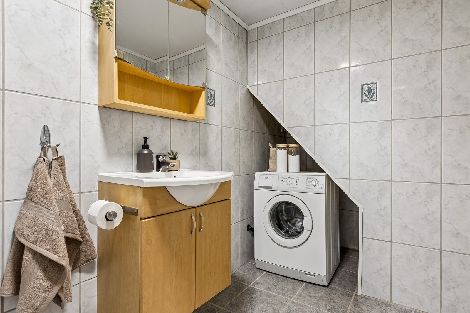 Det er utstyrt med en praktisk servantseksjon med speilskap og overlys, samt mekanisk ventilasjon og opplegg for vaskemaskin. Galleribilde