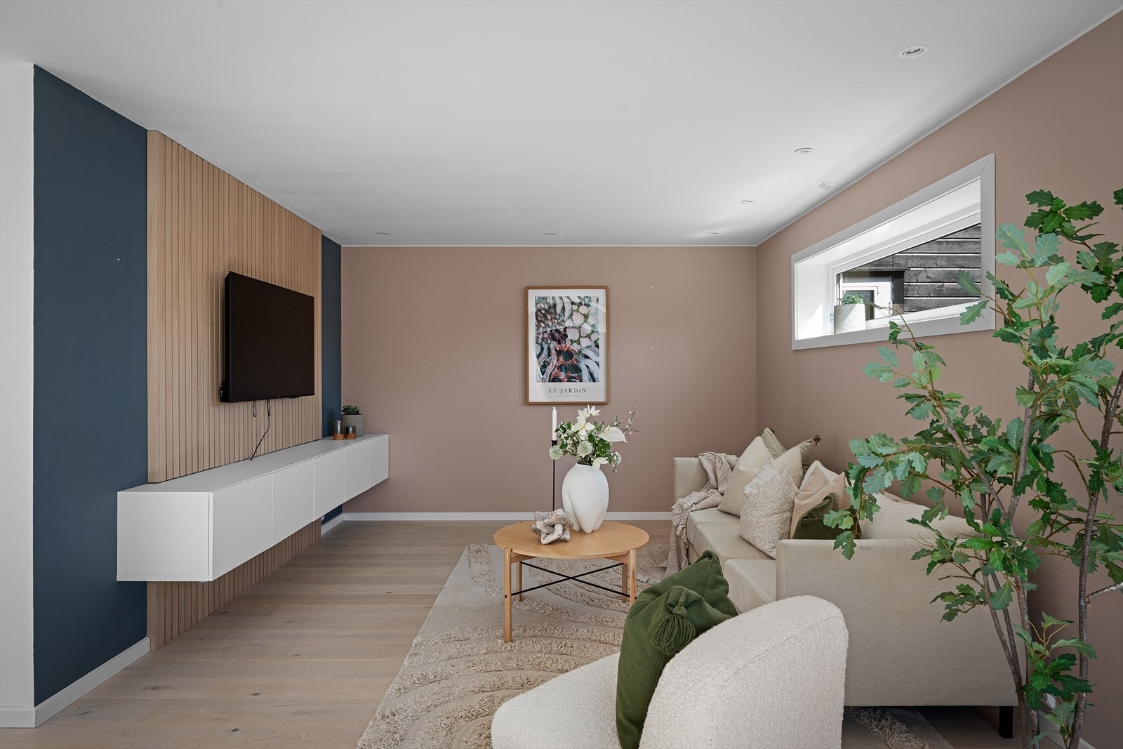 Stuen har god plass til en romslig sofagruppe. Spileveggen skaper en lun og definert sone for TV-kroken. Galleribilde