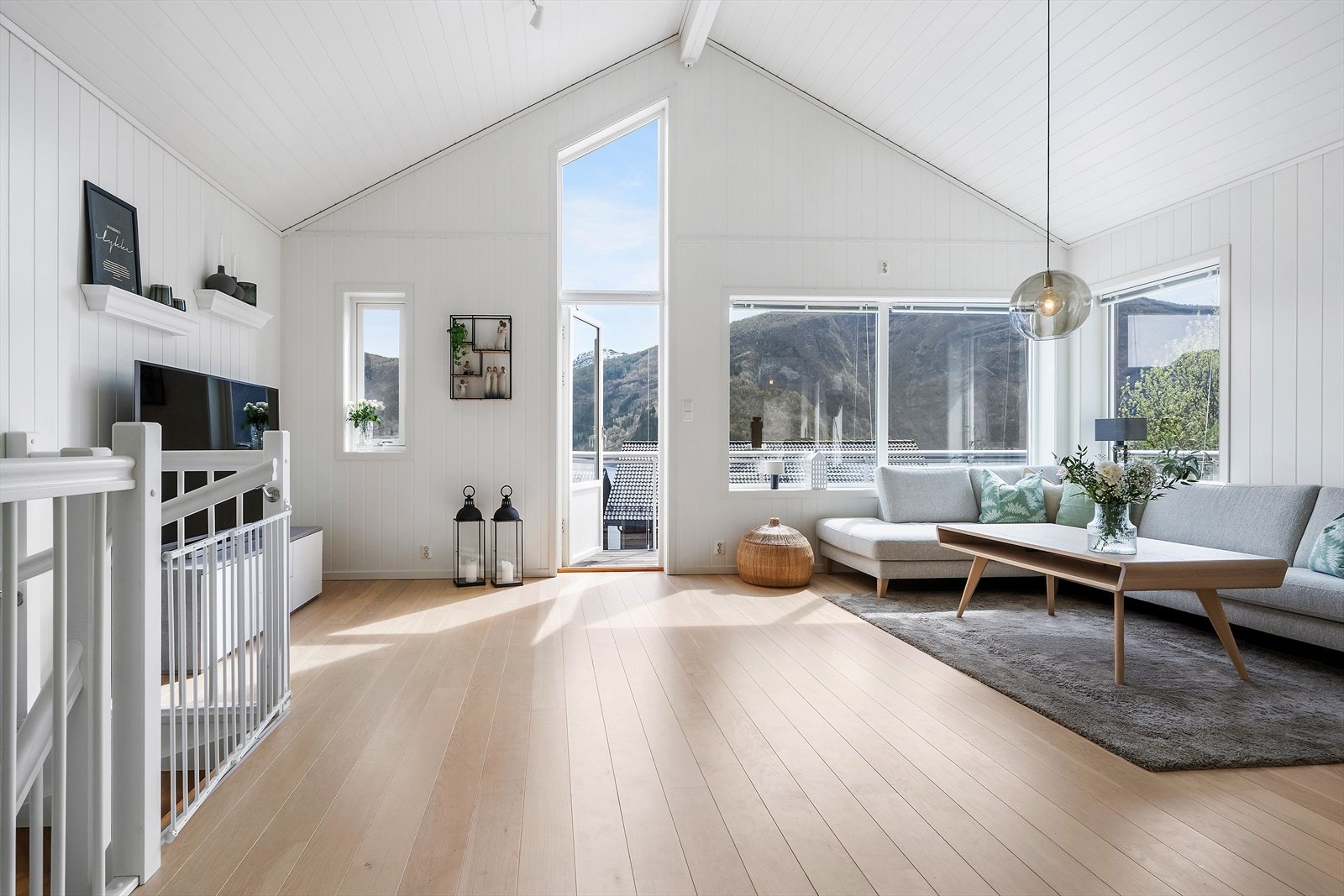 I andre etasje opnar bustaden seg opp med ei luftig stove med mønt himling og store vindauge. Galleribilde