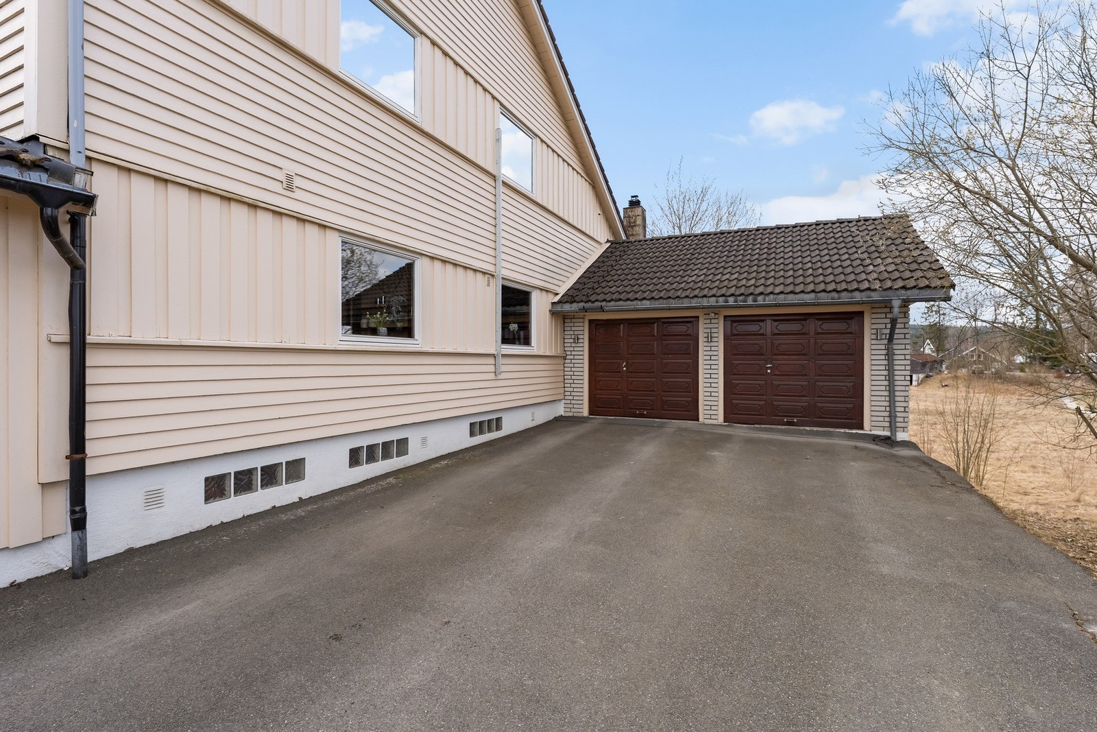 Romslig gårdsplass med parkering og dobbel garasje. Galleribilde