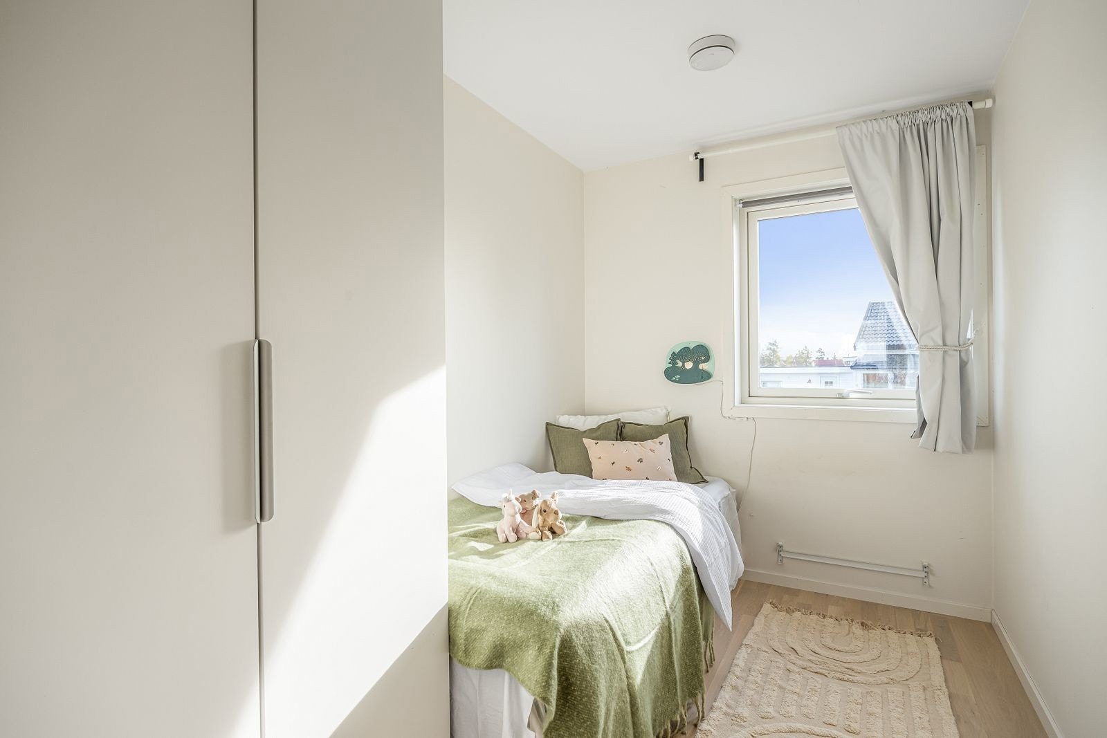 Lyst og koselig soverom med god garderobeløsning, store skap langs veggen og vindu som slipper inn naturlig lys - passer perfekt som barnerom eller gjesterom. Galleribilde