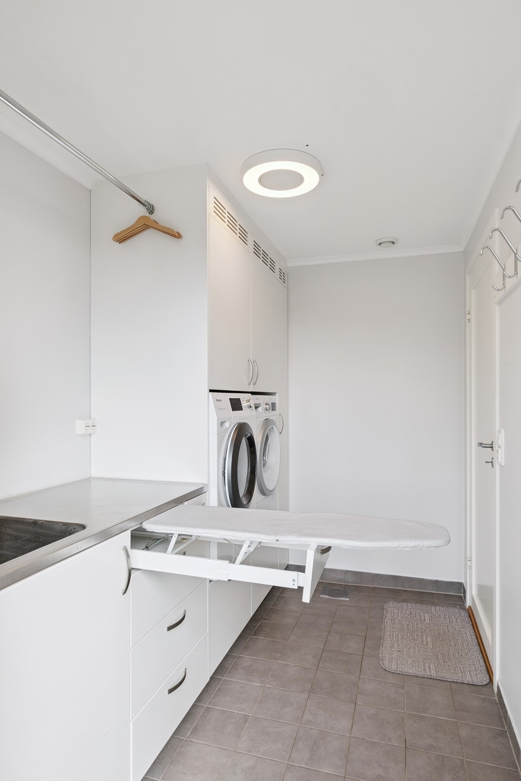 Vaskerom her vist med underskap med integrert strykebrett Galleribilde